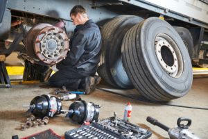 Truck,repair,service.,mechanic,works,with,brakes,in,truck,workshop