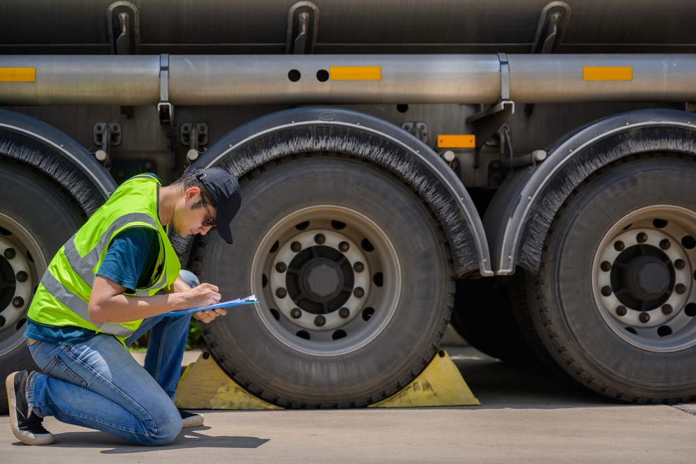 A,safety,inspector,inspects,the,tires,of,a,big,fuel