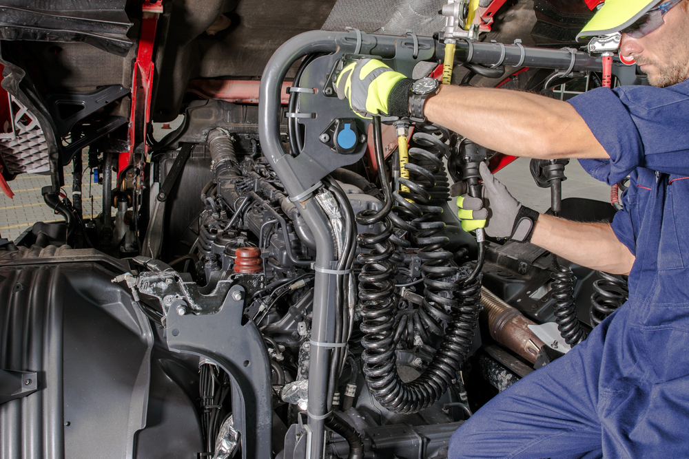 Caucasian,semi,truck,mechanic,performing,diesel,engine,maintenance,with,scheduled